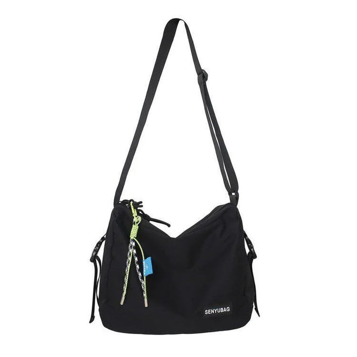 Black SENYUBAG shoulder bag with adjustable strap and neon green drawstring detail