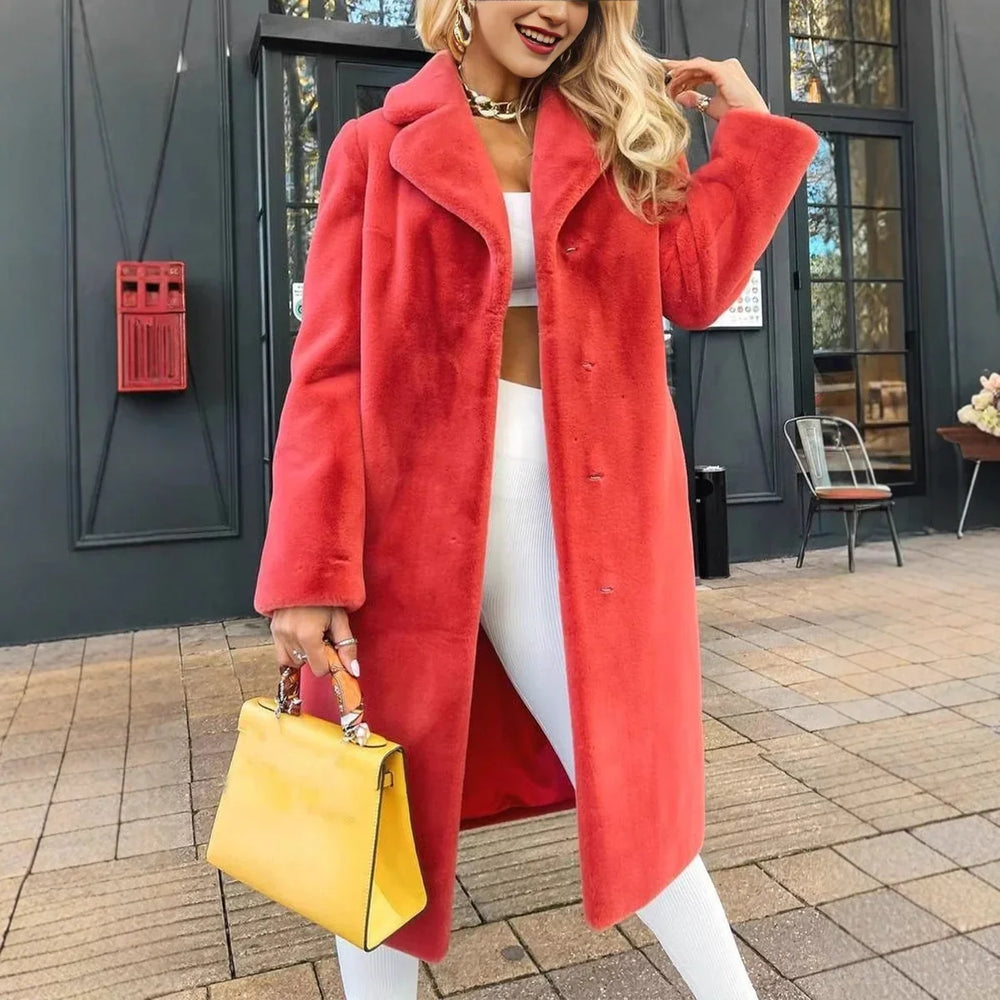 Woman wearing vibrant coral faux fur coat, white outfit, gold jewelry, and holding yellow handbag outdoors