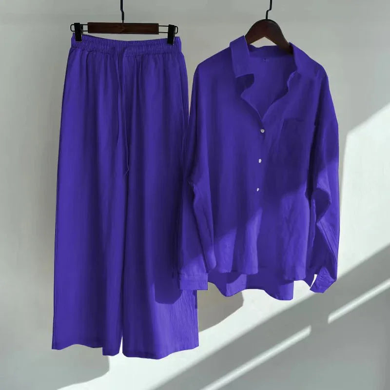 Purple casual loose-fit shirt and wide-leg pants set hanging on wooden hangers against light background