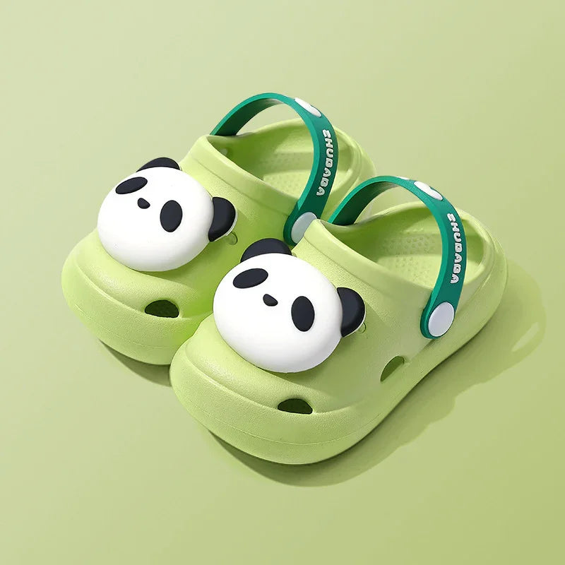 Light green kids clogs with panda face decoration and teal straps on solid background