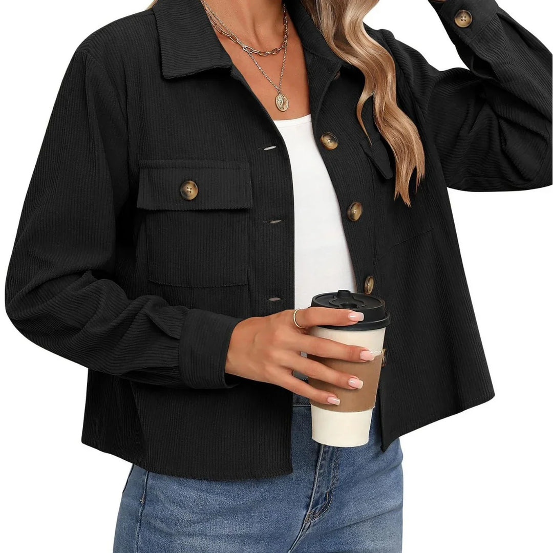Woman wearing black corduroy button-up jacket with pockets, holding takeaway coffee cup