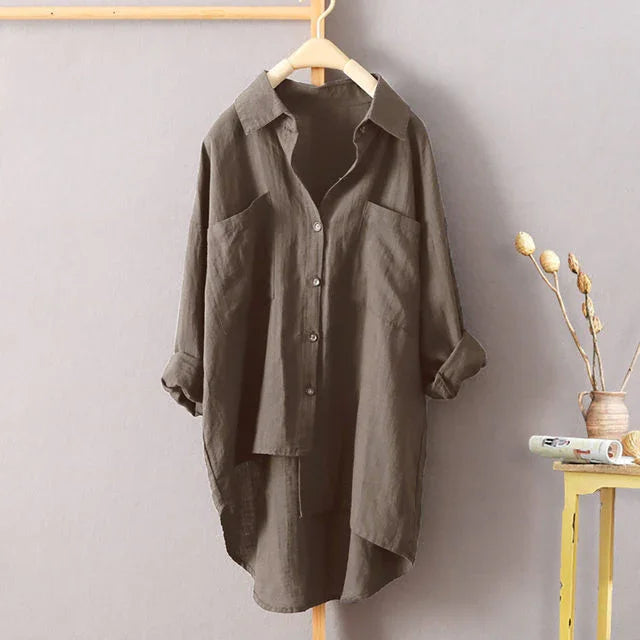 Brown oversized button-up shirt dress with rolled sleeves hanging on wooden rack