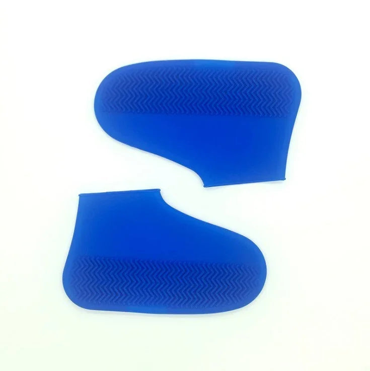Pair of blue silicone shoe covers with textured soles on white background