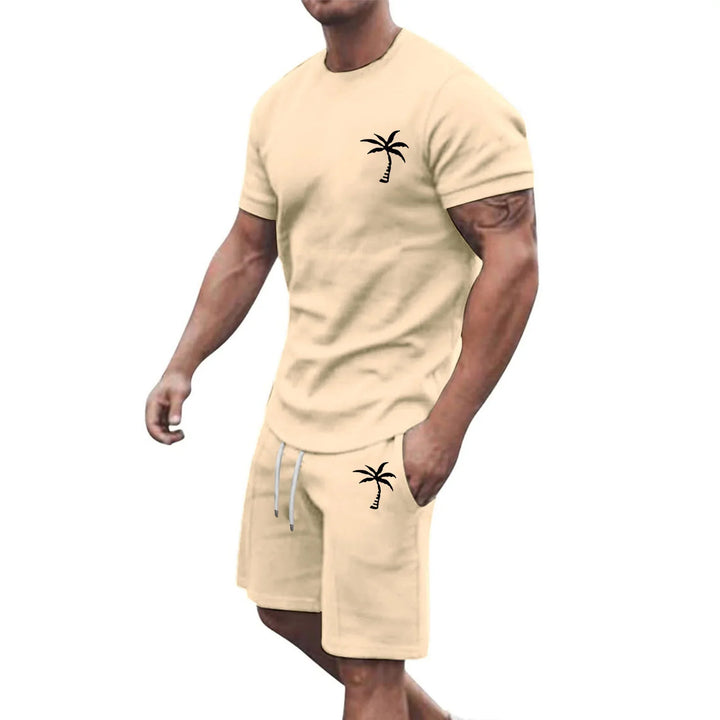 Man wearing beige short sleeve t-shirt and shorts set with black palm tree prints, casual summer outfit