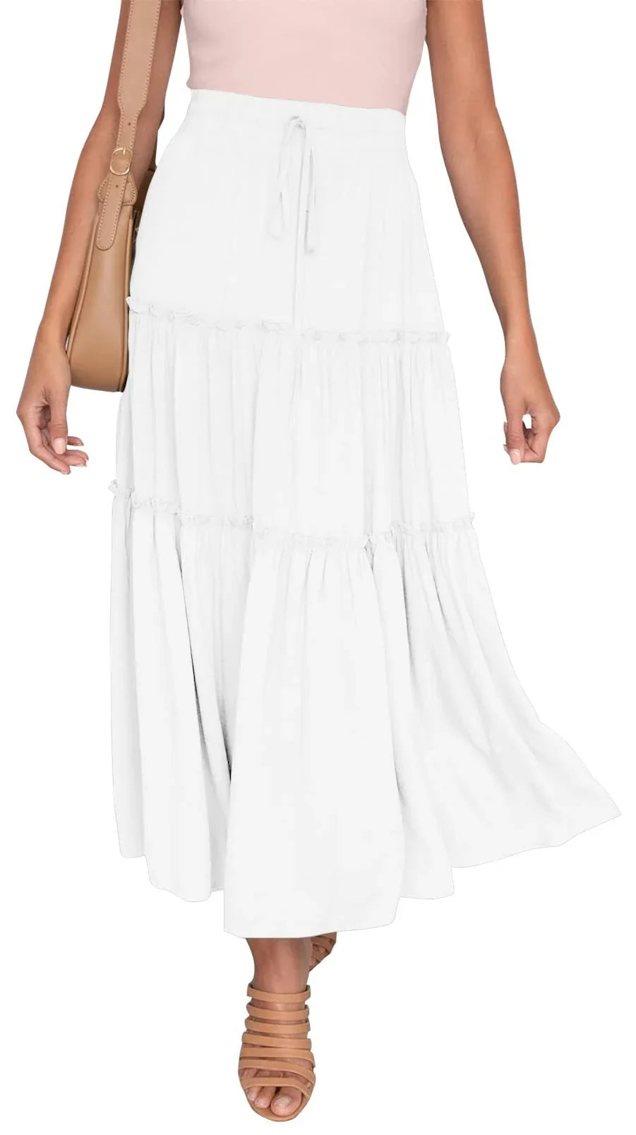 Woman wearing a white tiered maxi skirt with a drawstring waist, paired with tan strappy heels and carrying a tan shoulder bag