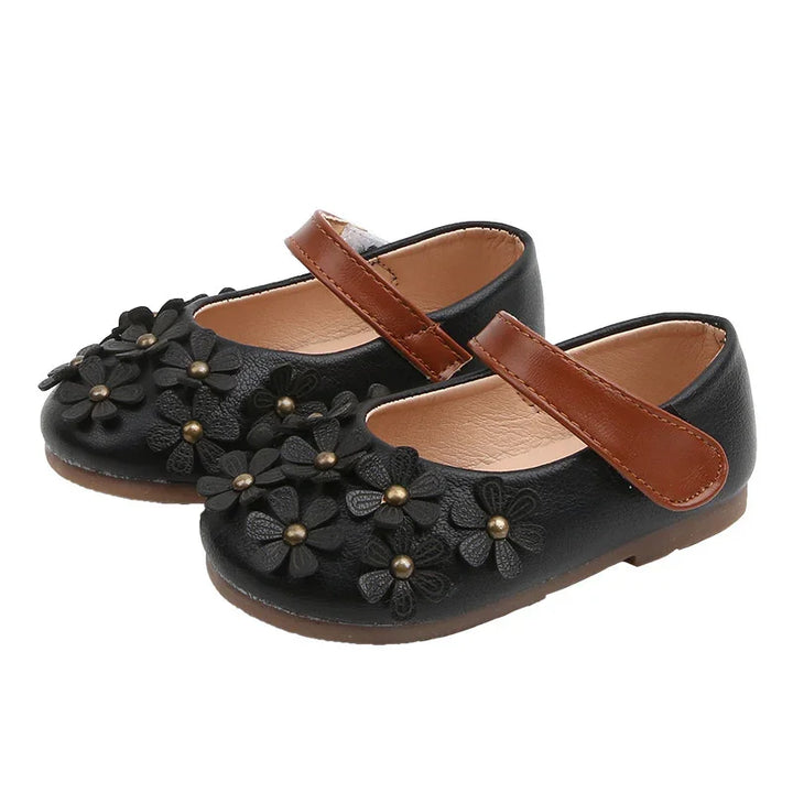 Black toddler Mary Jane shoes with brown straps and black flower embellishments with gold centers