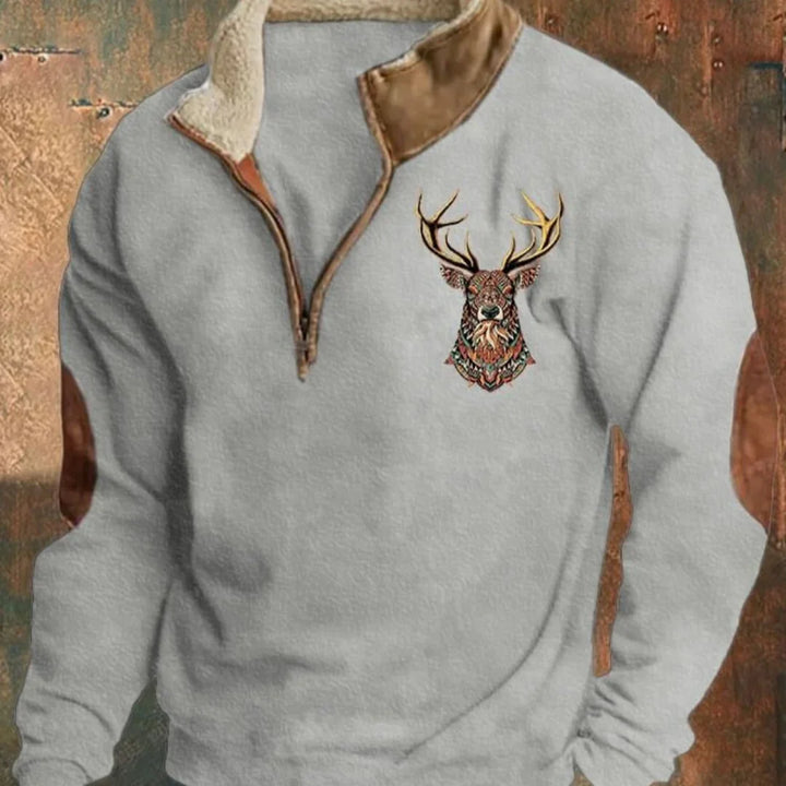 Light grey pullover with brown faux leather collar and elbow patches featuring colorful deer head embroidery