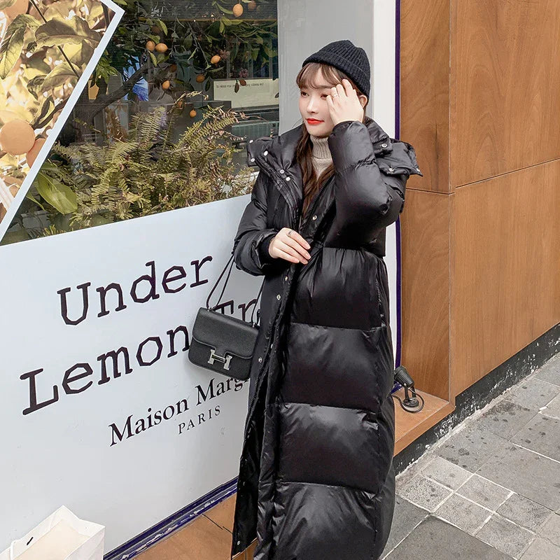 Woman in long black puffer coat and beanie standing outside a storefront with 'Under Lemon Tree' sign