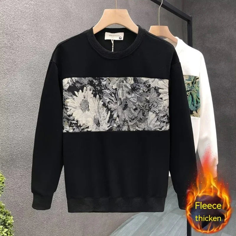 Black fleece sweatshirt with grey floral pattern panel, hanging on wooden hanger against grey background