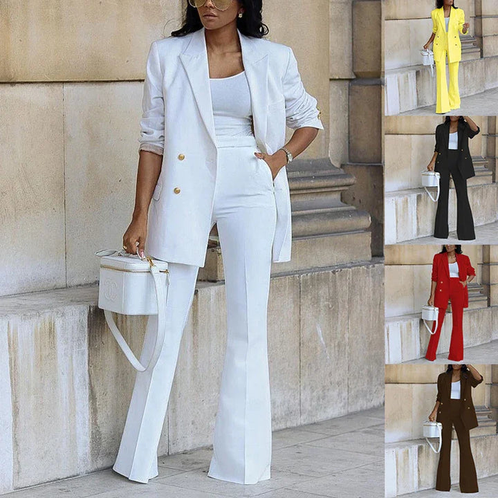 Woman wearing stylish white double-breasted blazer and matching flared pants holding white handbag, urban background