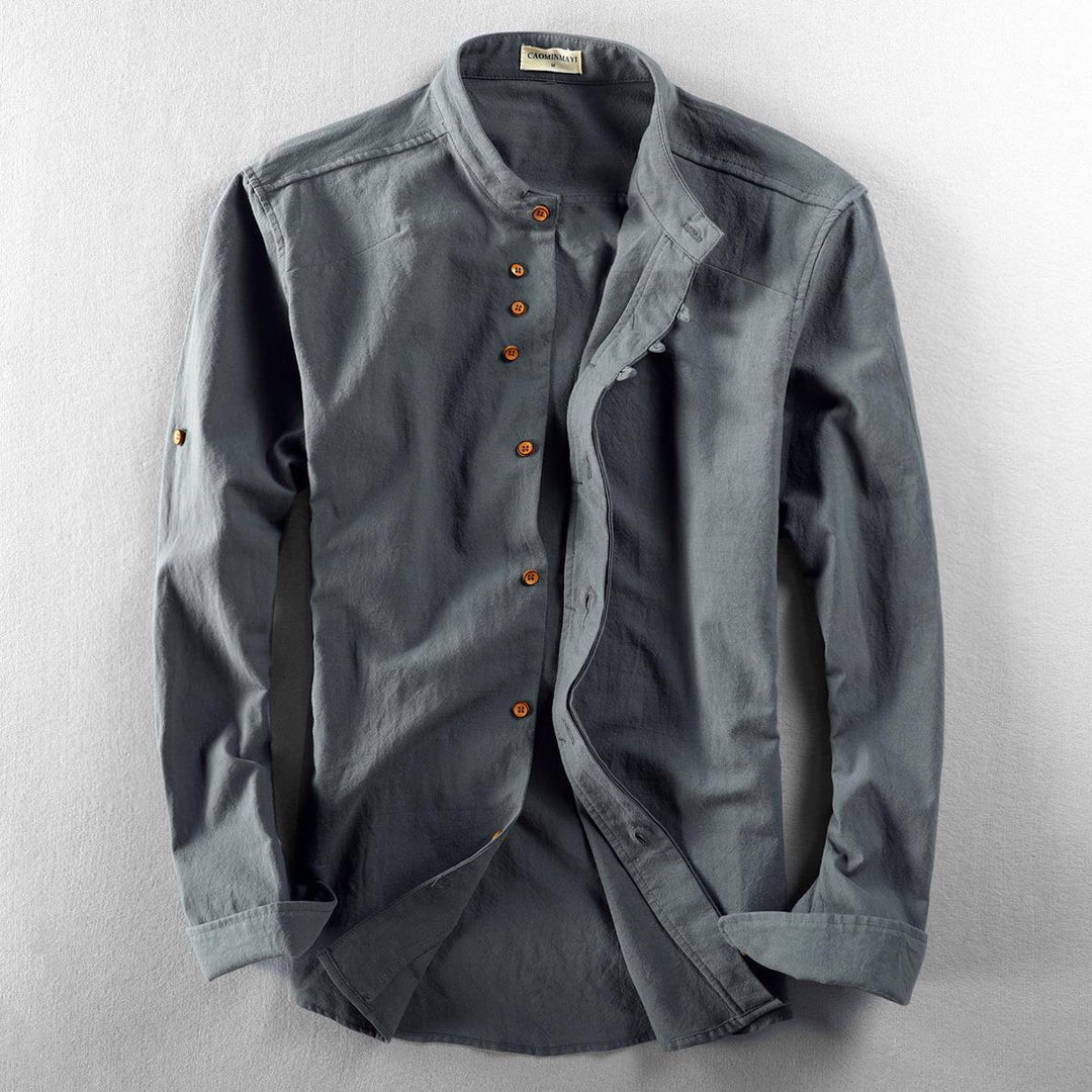 Men's grey cotton shirt with wooden buttons and mandarin collar laid flat on light surface