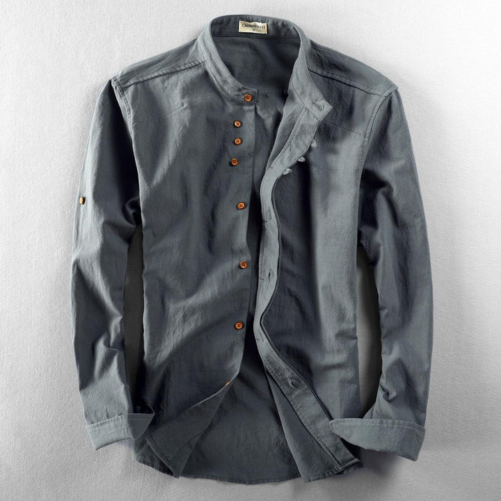 Men's long sleeve gray cotton shirt with mandarin collar and brown buttons, laid flat