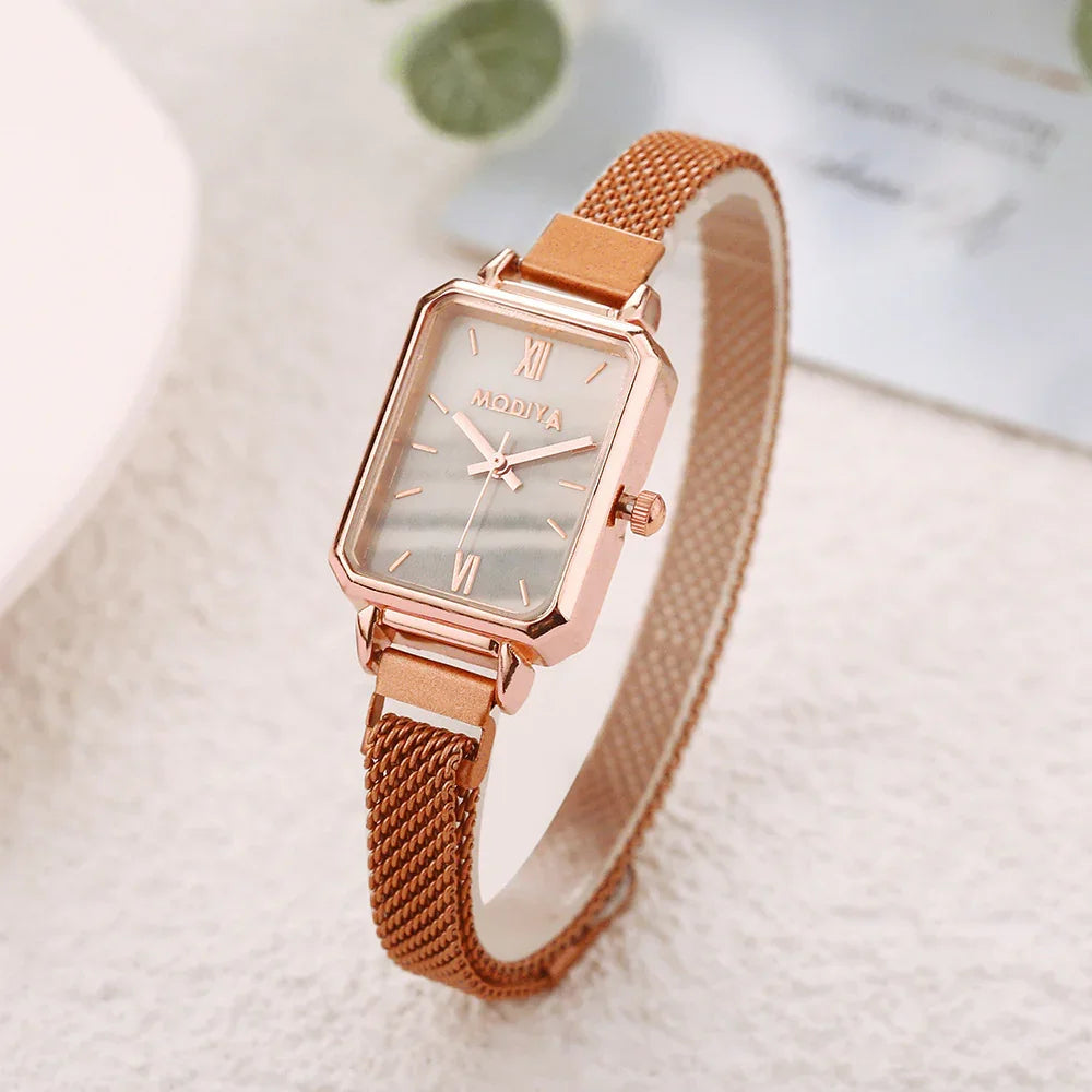 Rose gold MODIYA rectangular women's wristwatch with mesh strap on a textured surface