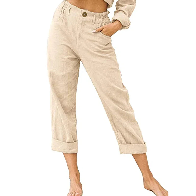 Woman wearing beige cropped casual pants with cuffed hems and elastic waist, posing barefoot