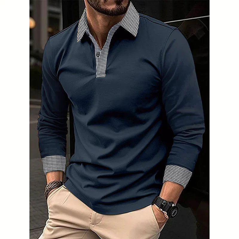 Man wearing navy blue long-sleeve polo shirt with houndstooth collar and cuffs, beige pants, and wrist accessories