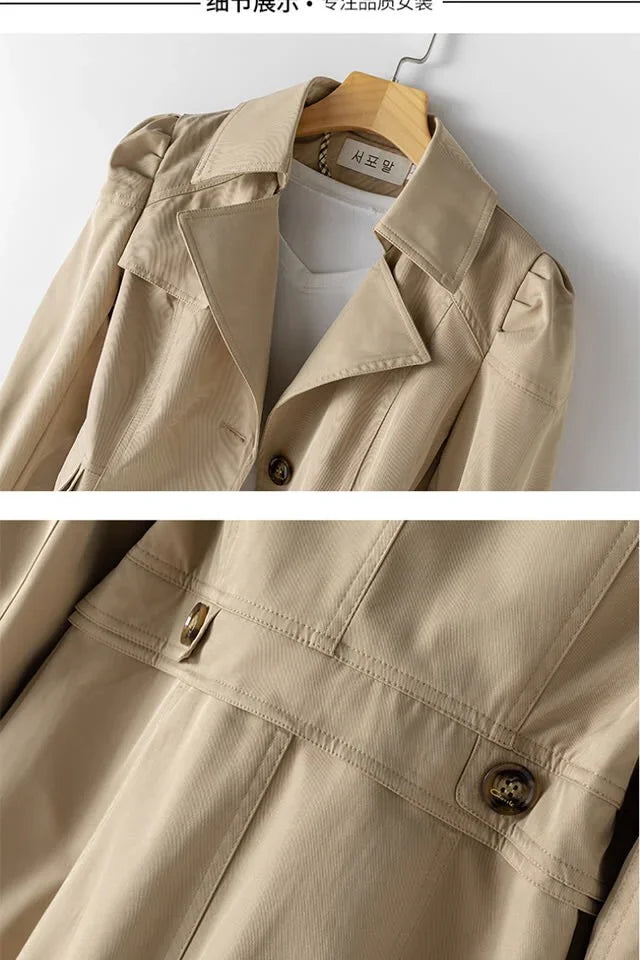 Beige trench coat with detailed stitching and buttons on hanger over white shirt