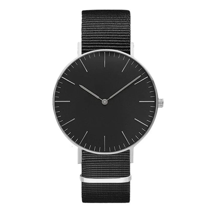 Minimalist black wristwatch with silver case and black nylon strap on white background