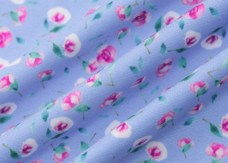 Light blue fabric with pink and white floral pattern, soft texture and folds