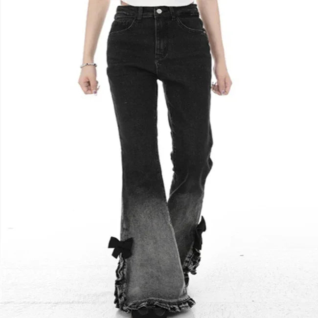 Black ombre flared jeans with ruffled hems and bow details on white background