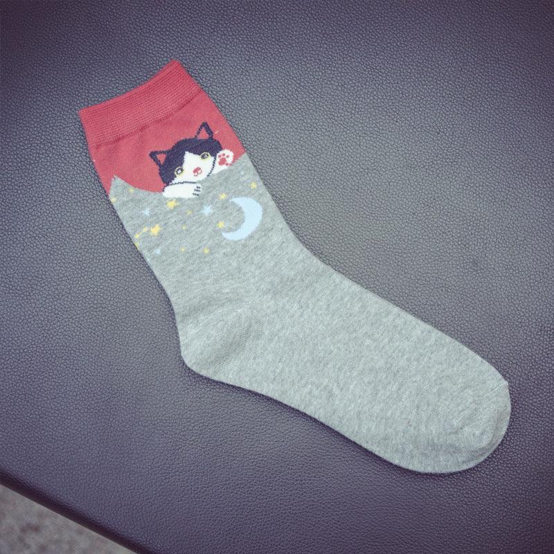 Grey sock with red cuff featuring a cute black and white cat peeking and moon and stars pattern