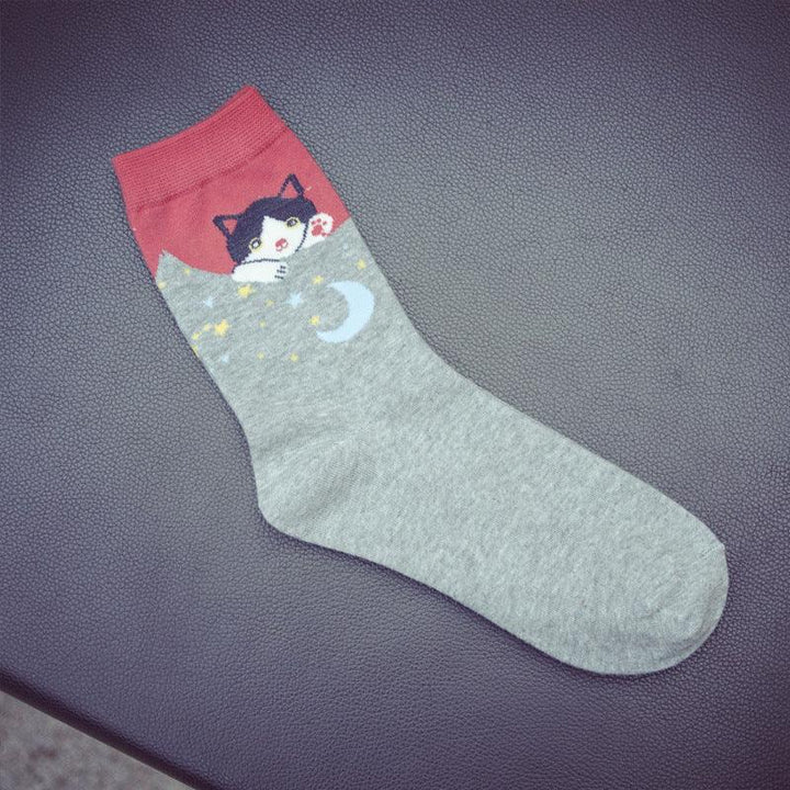 Grey sock with red cuff featuring a cute black and white cat peeking and moon and stars pattern