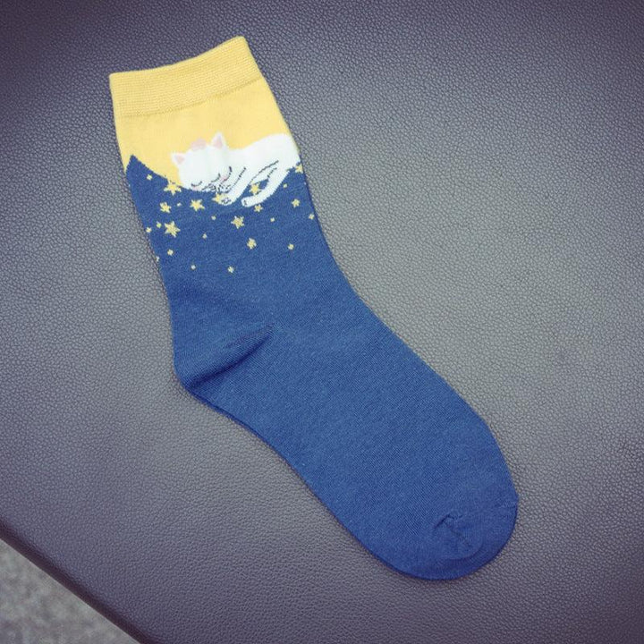 Blue and yellow sock with white cat sleeping on stars pattern