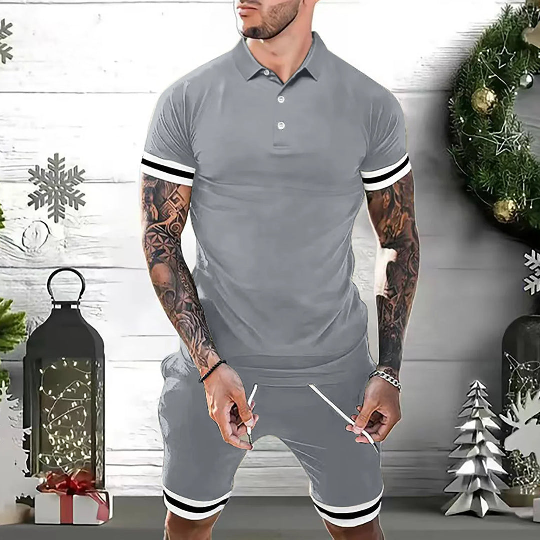 Man wearing gray polo shirt and matching shorts with black and white stripes, standing in festive holiday setting