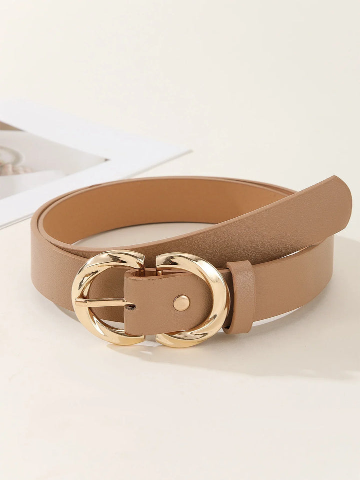 Beige leather belt with gold rounded buckle on neutral surface near open book