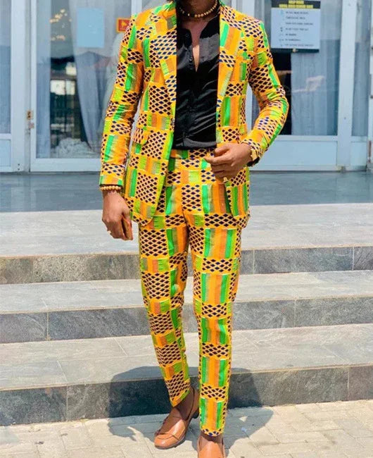 Man wearing vibrant yellow, green, and black patterned African print suit with black shirt and brown shoes outdoors