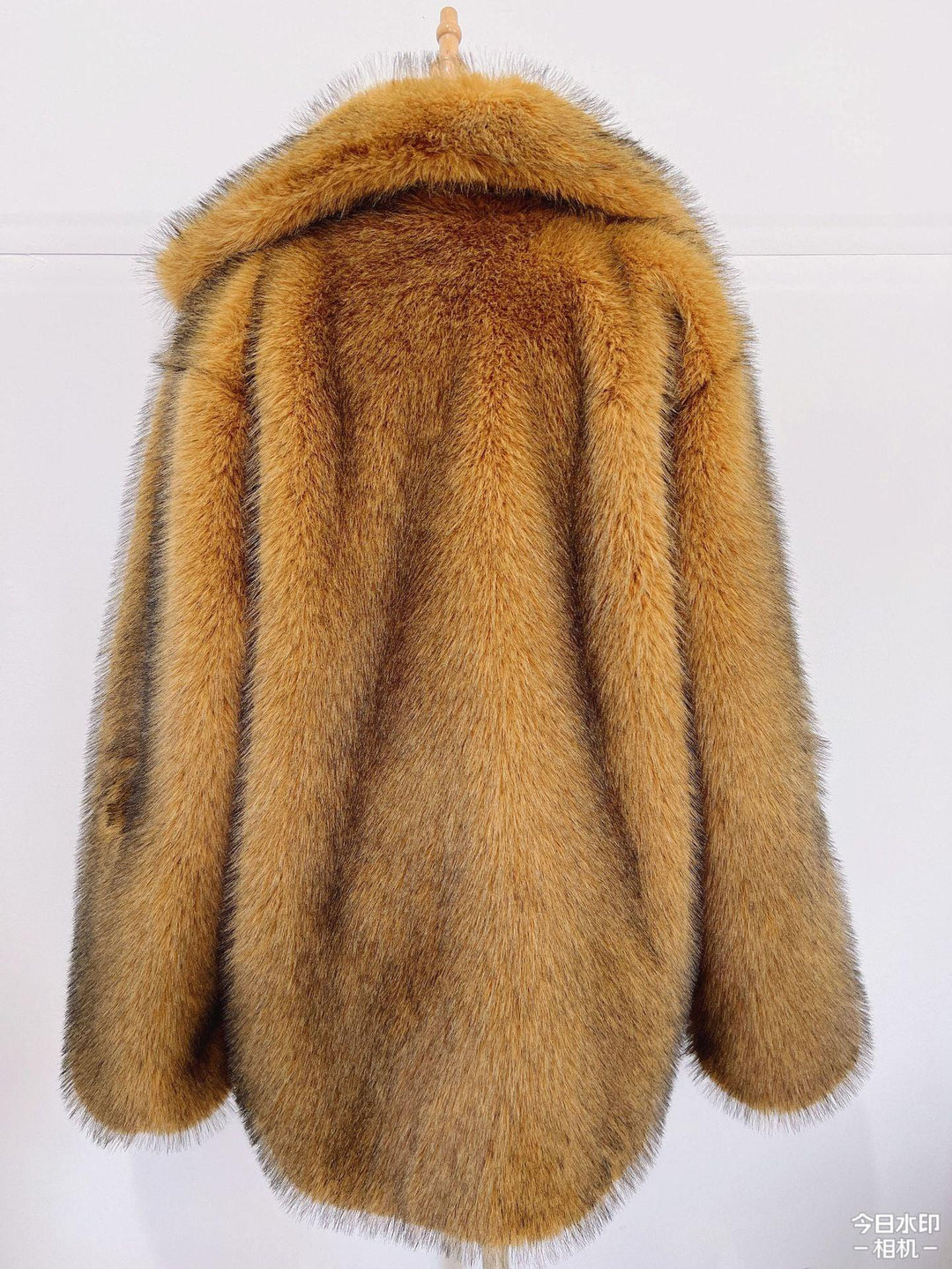 Back view of a brown fur coat with a wide collar hanging on a wooden hanger