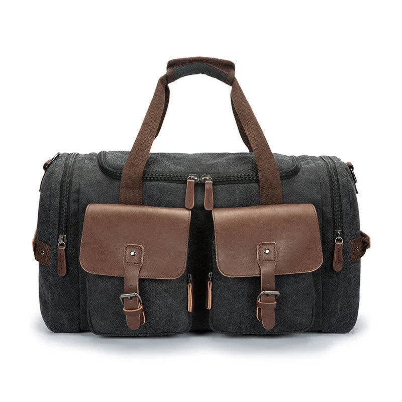 Dark gray canvas duffel bag with brown leather pockets, adjustable straps, and dual handles