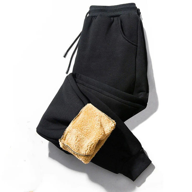 Black fleece jogger pants with beige sherpa lining and drawstring waist on white background