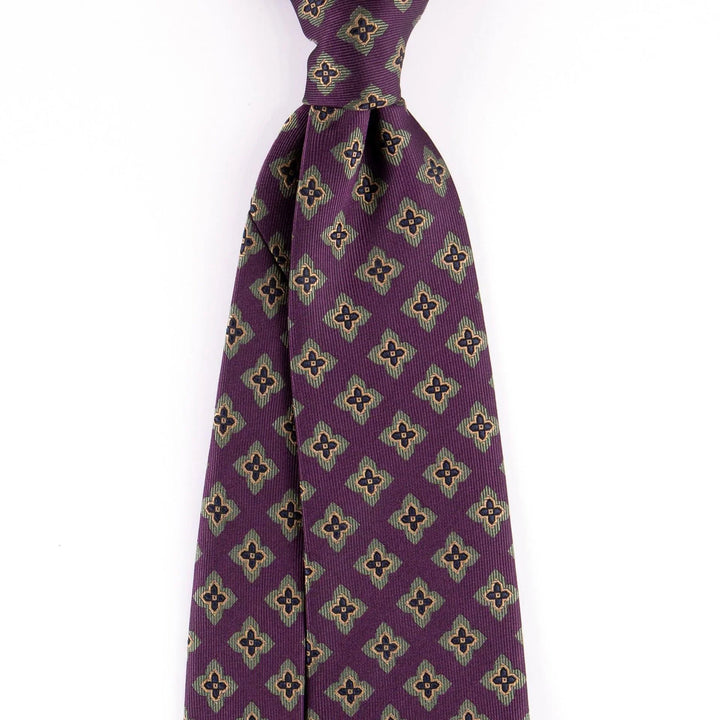 Purple patterned men's necktie with geometric floral design on white background