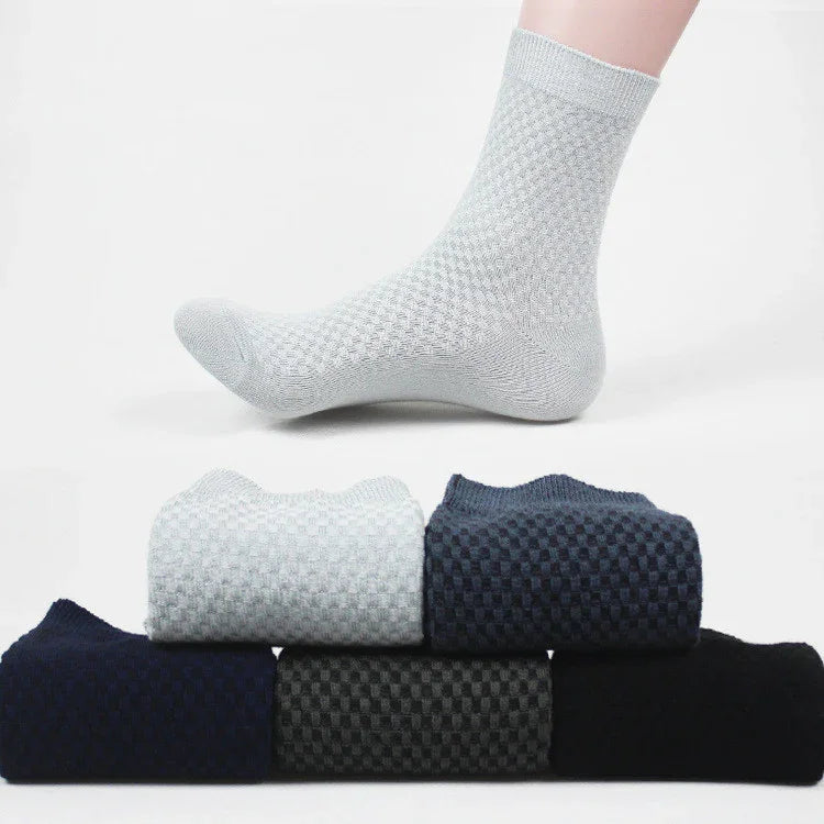 Light gray textured ankle sock worn on foot with five folded textured socks in navy, gray, black shades