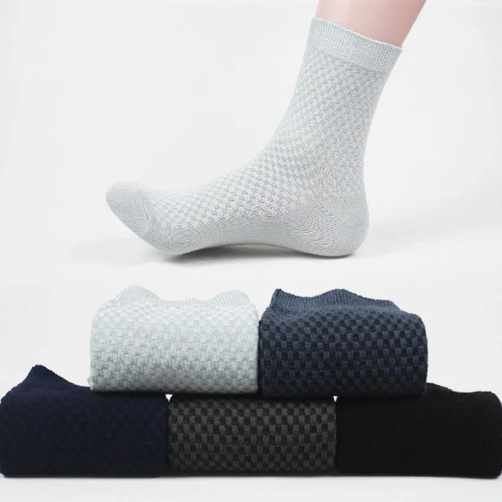Light gray textured ankle sock worn on foot with five folded textured socks in navy, gray, black shades
