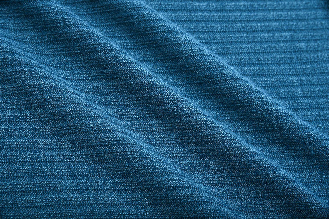 Close-up of textured blue knit fabric with visible detailed stitching pattern