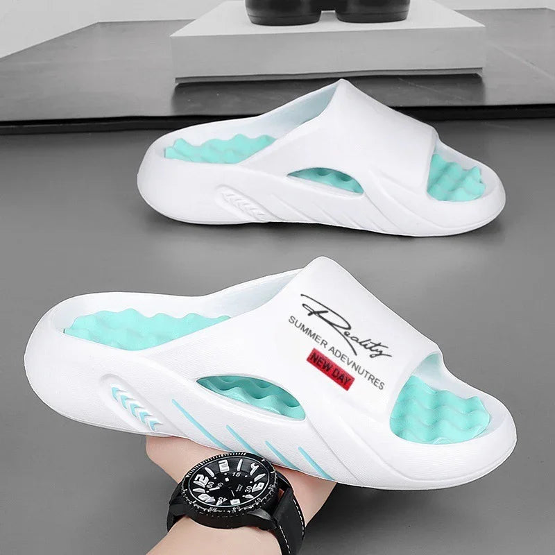 White summer sandals with turquoise textured insoles and black text design, held by hand with black watch