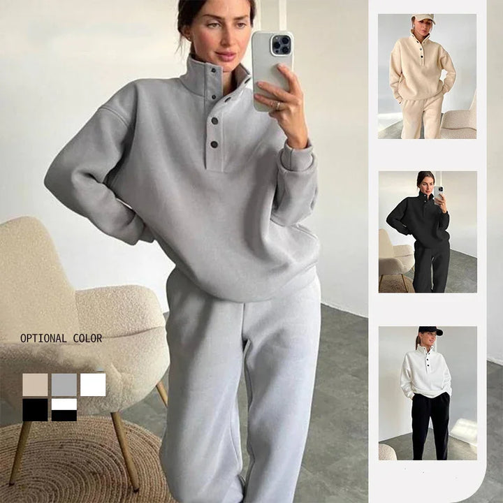 Woman wearing gray button-up pullover and matching sweatpants taking mirror selfie in modern room