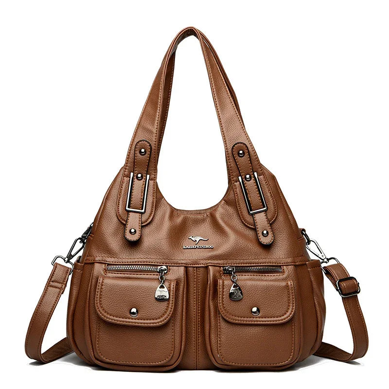 brown leather handbag with dual front pockets, zipper details, adjustable shoulder strap, and top handles