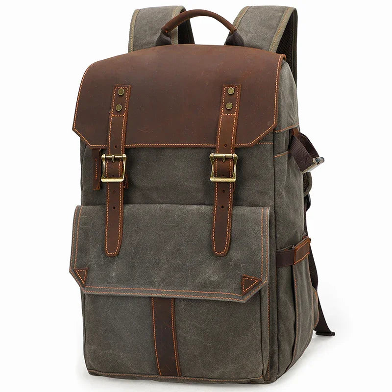 Vintage style grey canvas backpack with brown leather flap and brass buckle straps