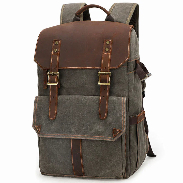 Vintage style grey canvas backpack with brown leather flap and brass buckle straps