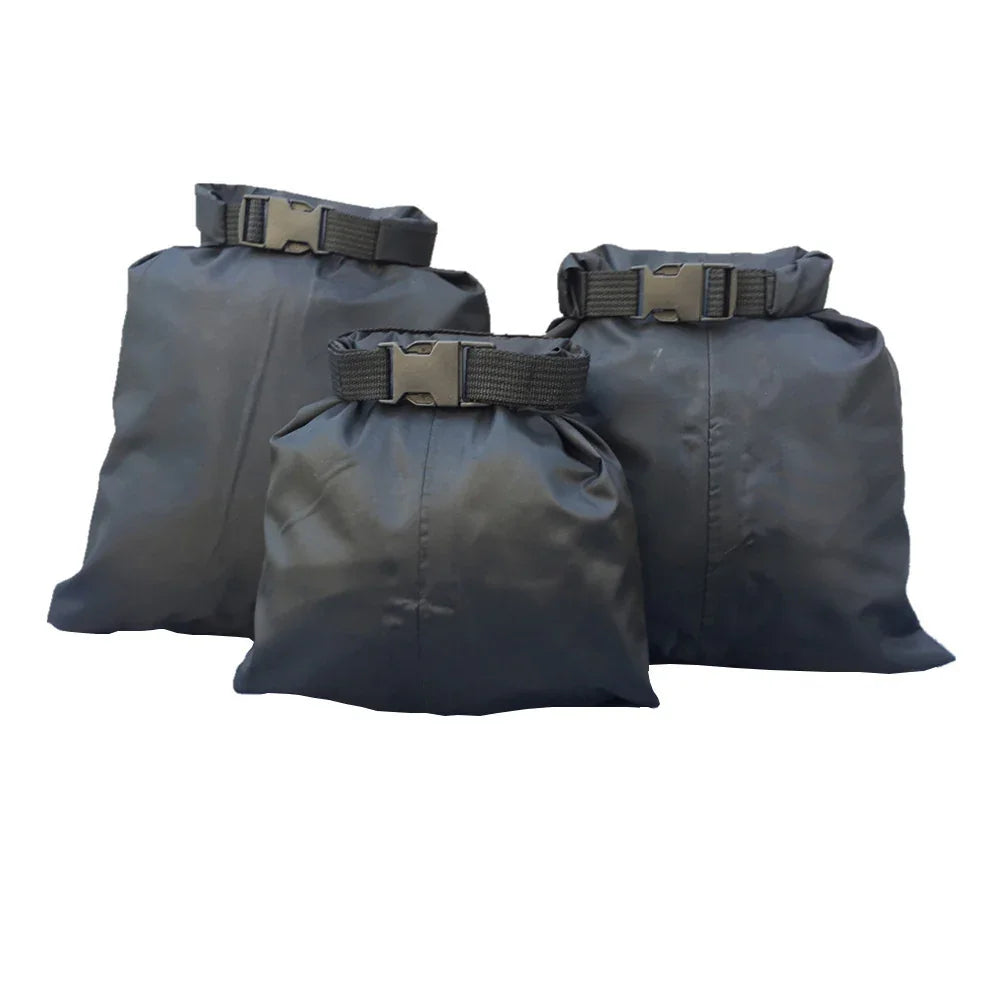 Set of three black waterproof dry bags with buckle closures on a white background