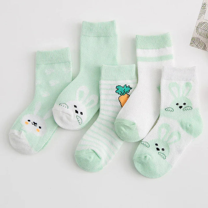 Set of five pastel green and white baby socks with bunny faces and carrot designs