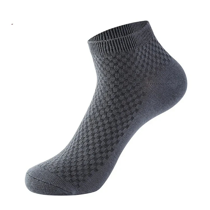 Dark gray ankle sock with textured diamond pattern and ribbed cuff on white background