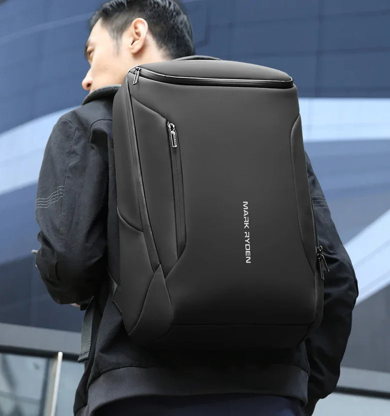 man wearing black Mark Ryden backpack in urban setting with modern building background