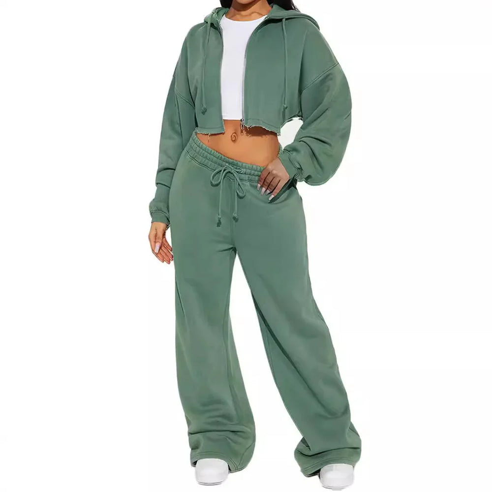 Woman wearing sage green cropped hoodie and matching wide-leg sweatpants with white sneakers