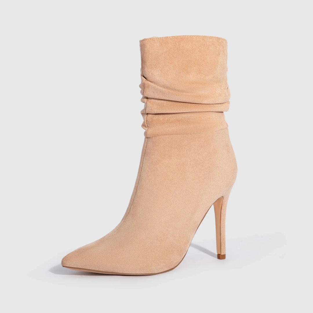 Beige suede pointed-toe ankle boot with slouchy shaft and stiletto heel on white background