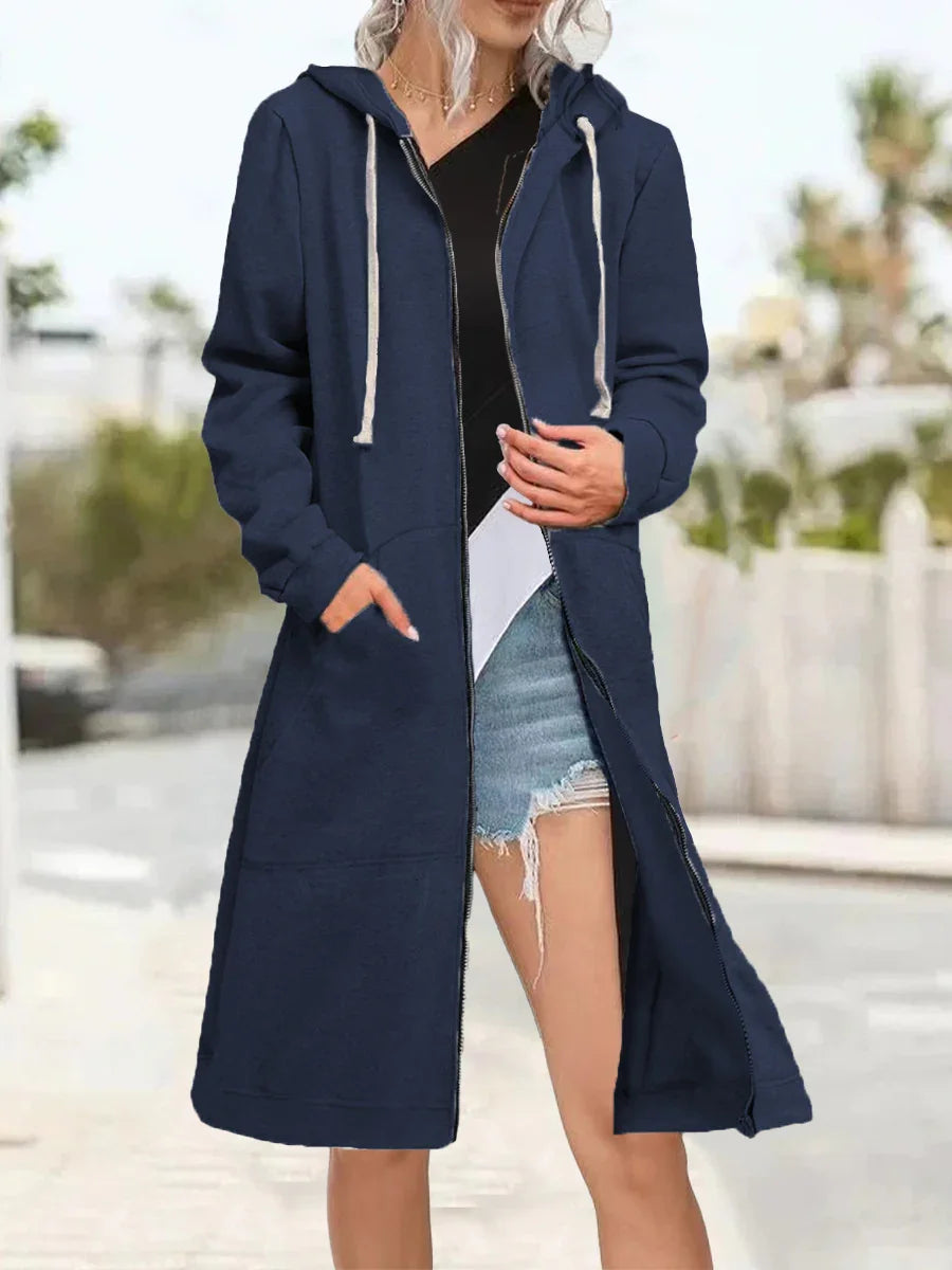 Woman wearing long navy blue zip-up hoodie with white drawstrings and denim shorts outdoors