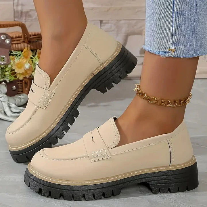 Beige chunky sole loafers worn with a gold chain ankle bracelet and cropped light blue jeans