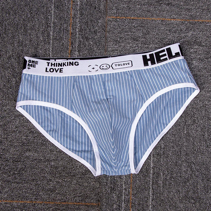 Blue and white striped men's briefs with white waistband featuring text and smiley face graphic on gray carpet